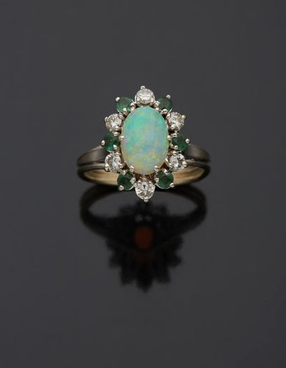 null An 18K white gold 750‰ ring, adorned with an opal within an alternating surround...