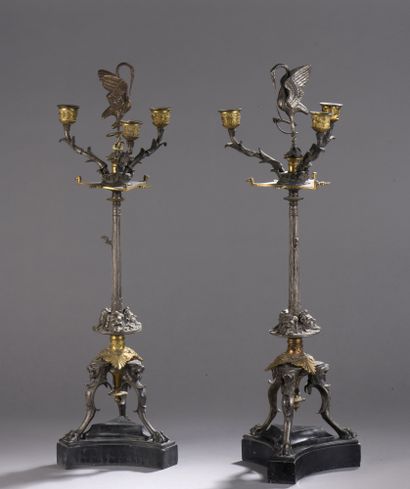 null A pair of silvered and gilt bronze candelabras with three lights, decorated...