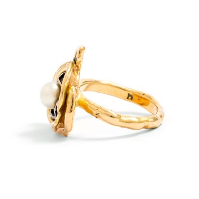 null Ring representing a stylized flower in 18K gold 750/1000th centered of a pearl.

Dimensions...