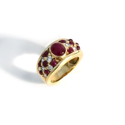 null An 18K yellow gold ring set with round diamonds and cabochon-cut rubies, centered...