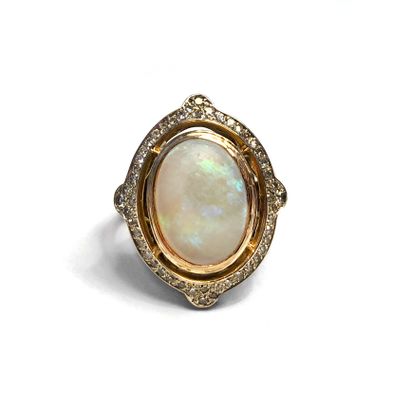 null An 18K yellow gold ring centered on an opal surrounded by diamonds.

Finger...