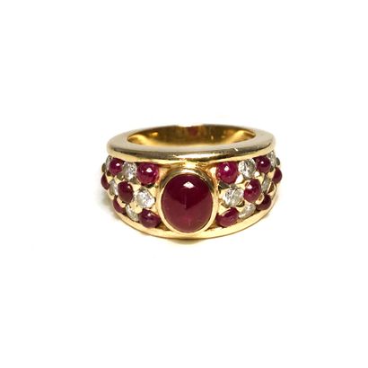 null An 18K yellow gold ring set with round diamonds and cabochon-cut rubies, centered...
