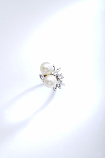 null An 18K white gold ring holding two pearls surrounded by round diamonds.

Finger...