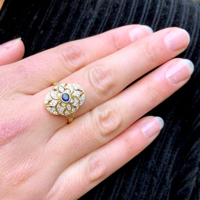 null An 18K yellow gold ring set with diamonds and centered with a sapphire.

Finger...