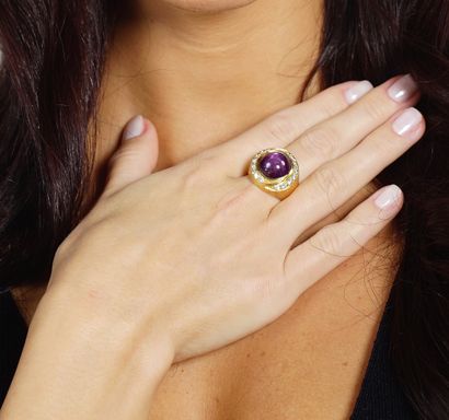 null Ring in 18K yellow gold 750/1000th centered with a cabochon-cut star ruby surrounded...