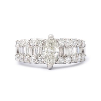 null An 18K white gold ring set with round and baguette-cut diamonds centered on...