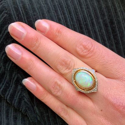 null An 18K yellow gold ring centered on an opal surrounded by diamonds.

Finger...