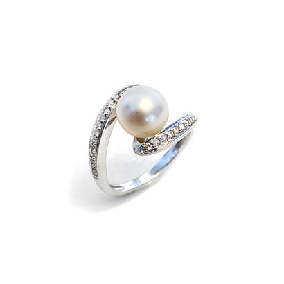 null An 18K white gold ring set with round diamonds, centered on a pearl.

Finger...