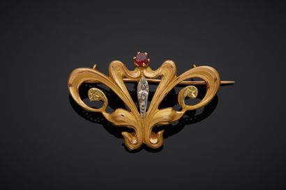 null An 18K 750‰ two-tone gold brooch, adorned with floral scrolls, set with red...
