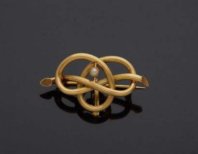 null 18K yellow gold 750‰ brooch, representing a knotted branch, set with a half...