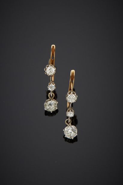 null A pair of 18K two-tone gold 750‰ sleeper earrings, adorned with old-cut diamonds...
