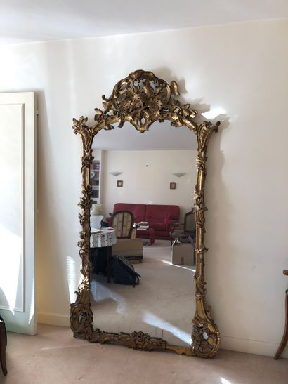 null Grand miroir en bois et stucs dorés à fronton ajouré, à décor rocaille et de...