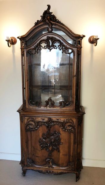 null A molded and carved wooden display case, opening with a glass door and a door...