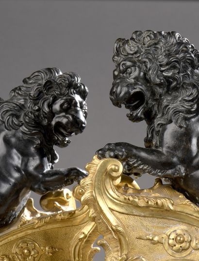 null PAIRE DE CHENETS en bronze patiné et bronze doré représentant deux lions rugissant...