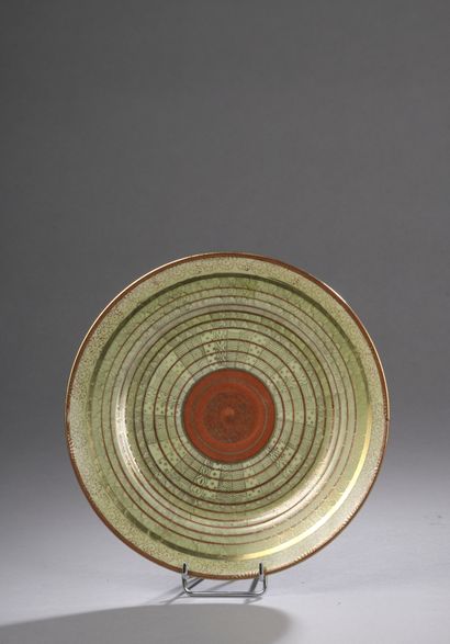 null Porcelain plate decorated in copper red underglaze and gold overglaze on a celadon...