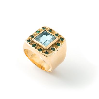 null 18K yellow gold ring centered on a square-cut aquamarine surrounded by emeralds.

Misses,...