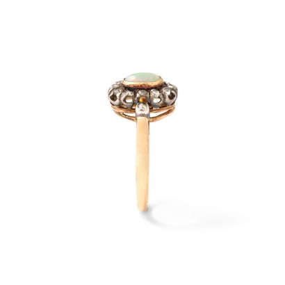 null 18K yellow and white gold ring set with an opal surrounded by rose-cut diamonds.

Scratches.

Opal...