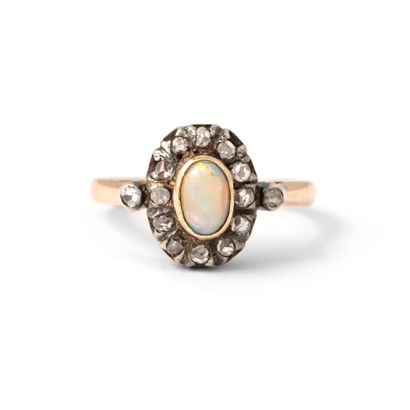 null 18K yellow and white gold ring set with an opal surrounded by rose-cut diamonds.

Scratches.

Opal...