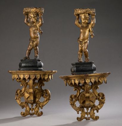 null PAIR OF STATUTE of putti in carved and gilded wood, holding a laurel torus on...