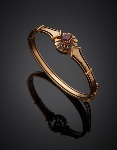 null Rigid bracelet in 18K yellow gold 750‰, set in its center with a round garnet...