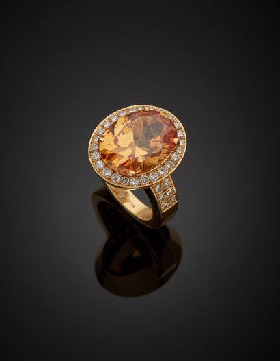 null An 18K yellow gold 750‰ ring, adorned at its center with a yellow stone in a...