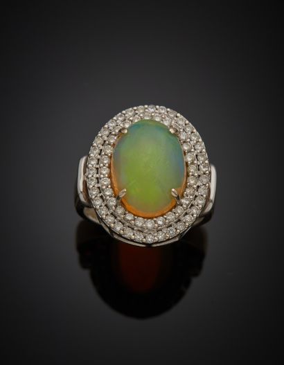 null An 18K white gold 750‰ oval ring set with a cabochon-cut opal within a double...