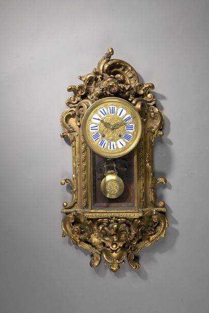 Wall clock in richly carved and gilded wood...