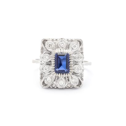 null 18K white gold 750‰ ring centered with an emerald cut blue stone surrounded...