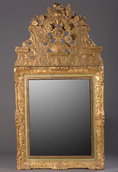 Mirror in a gilded wood frame, surmounted...