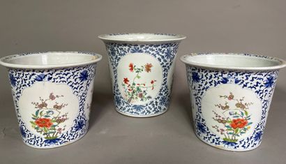 null Trois cache-pots dont une paire, en porcelaine, à décor polychrome d'arbustes...