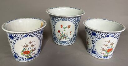 null Trois cache-pots dont une paire, en porcelaine, à décor polychrome d'arbustes...