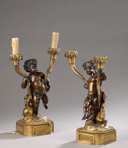 null Pair of two-light candelabra in patinated and gilded bronze, decorated with...