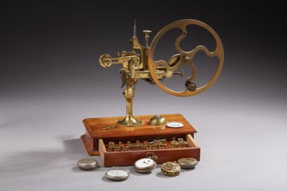null Brass watchmaker's tower, standing on a drawer box, lined with various utensils....