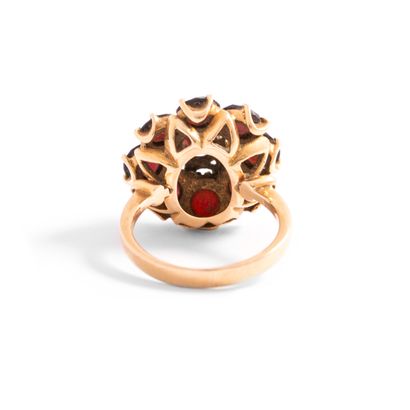 null 18K yellow gold 750‰ flower-shaped ring set with red stones. 

Stones chipped...