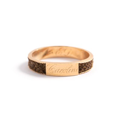 null 9K rose gold ring 375‰, adorned with a weave of hair and an engraved plaque.

Deformations...