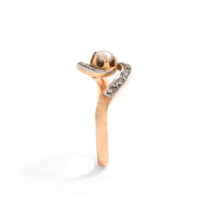 null Two-tone 18K gold 750‰ swirl ring, adorned at its center with a button-shaped...