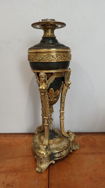 null Tripod oil lamp in black lacquered metal and gilt bronze decorated with winged...