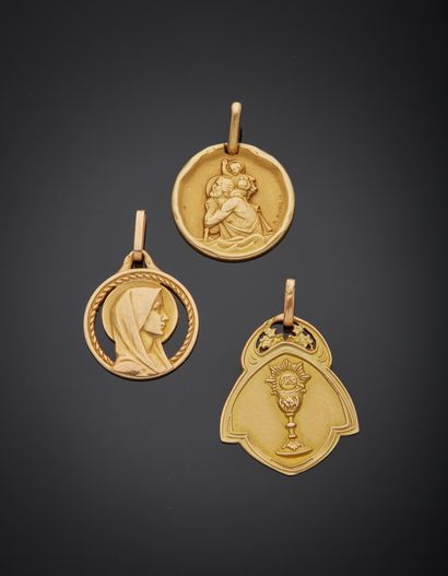 null Lot comprising three 18K yellow gold 750‰ medals, a communion medal, a St. Christopher...