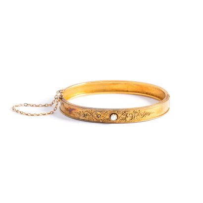 null Rigid 18K yellow gold 750‰ filigree scroll pattern bracelet holding a cultured...