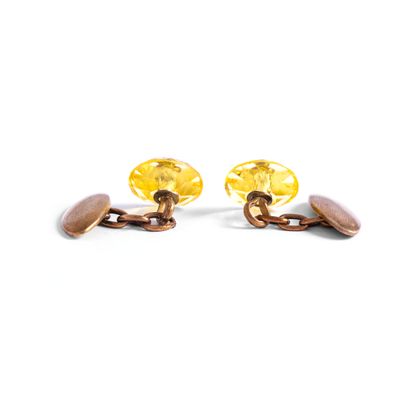 null Pair of gilded metal cufflinks holding respectively a faceted yellow stone....