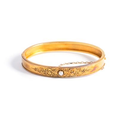 null Rigid 18K yellow gold 750‰ filigree scroll pattern bracelet holding a cultured...