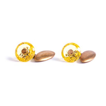 null Pair of gilded metal cufflinks holding respectively a faceted yellow stone....