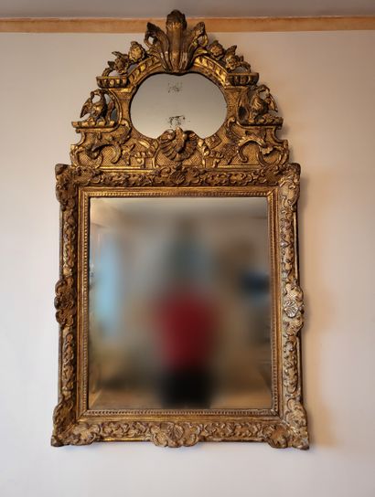 null Mirror in a gilded wood frame carved with scrolls and shells. The pediment is...