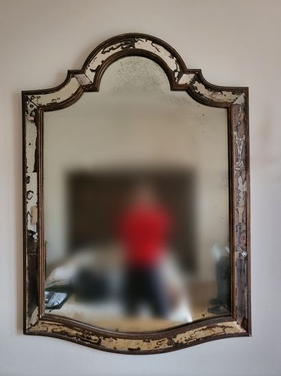 null Miroir cintré à parecloses dans un encadrement en bois patiné. 
119 x 85 cm