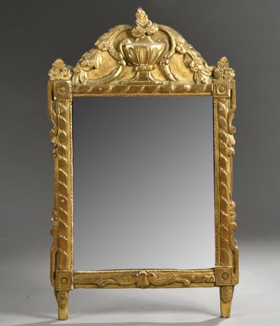 null MIRROR in a pedimented frame in carved and gilded wood decorated with flowered...