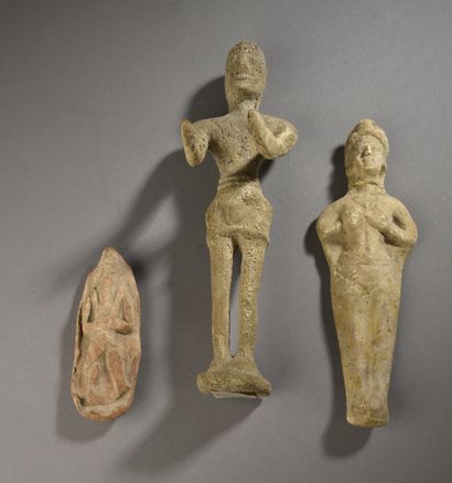 null LOT composed of TWO votive STATUETTES modeled in high relief: a bearded deity...