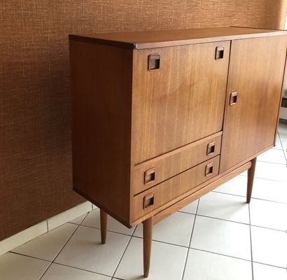 null Teak sideboard opening with a leaf, a flap and two drawers. Tapered legs.
Work...