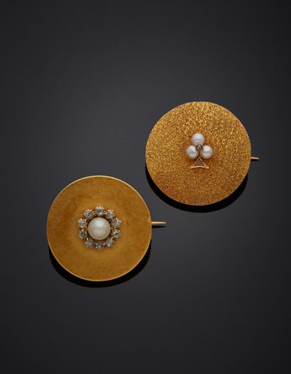 null **Two 18K yellow gold 750‰ round brooches, one set in its center with a button-shaped...