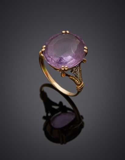 null Ring in two-tone 18K gold 750‰, set with an amethyst, shouldered by two old-cut...