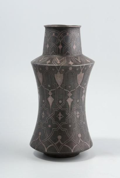 Un vase en métal noir décoré d'incrustations...